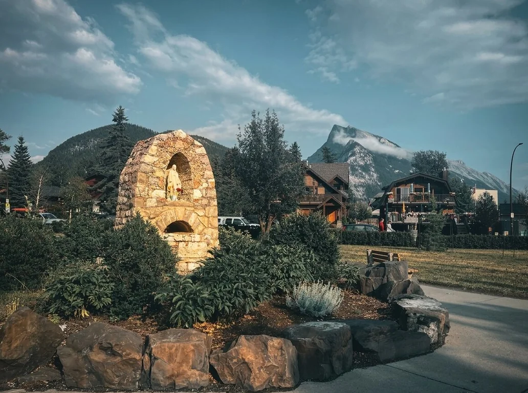 Stone arch monument in Banff with mountain backdrop