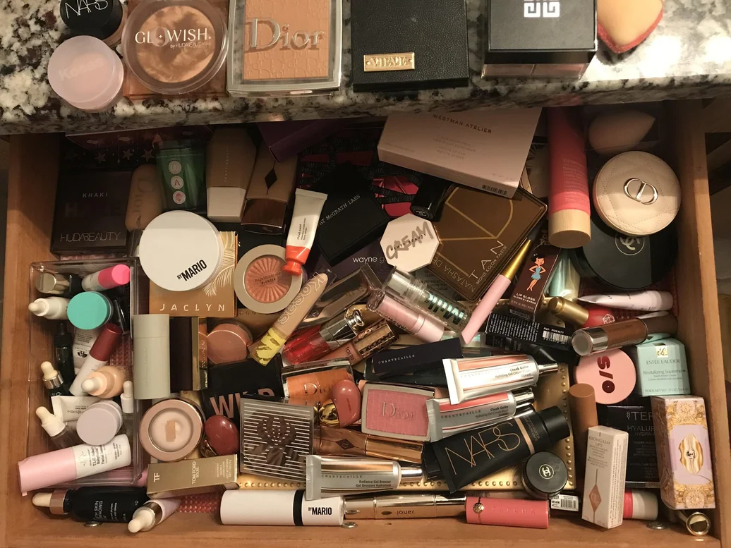 Overfull makeup drawer with products piled on top of each other