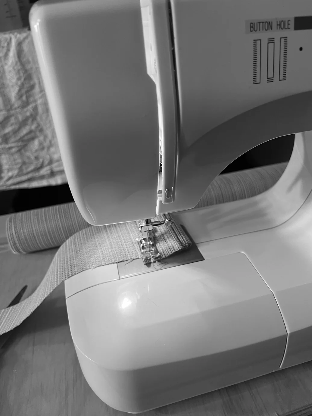 Sewing machine stitching the woven outdoor fabric — attaching the shade to the frame