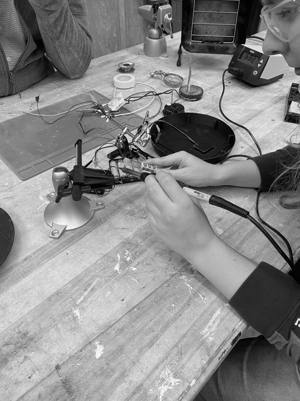 Circuit components being soldered at a workbench