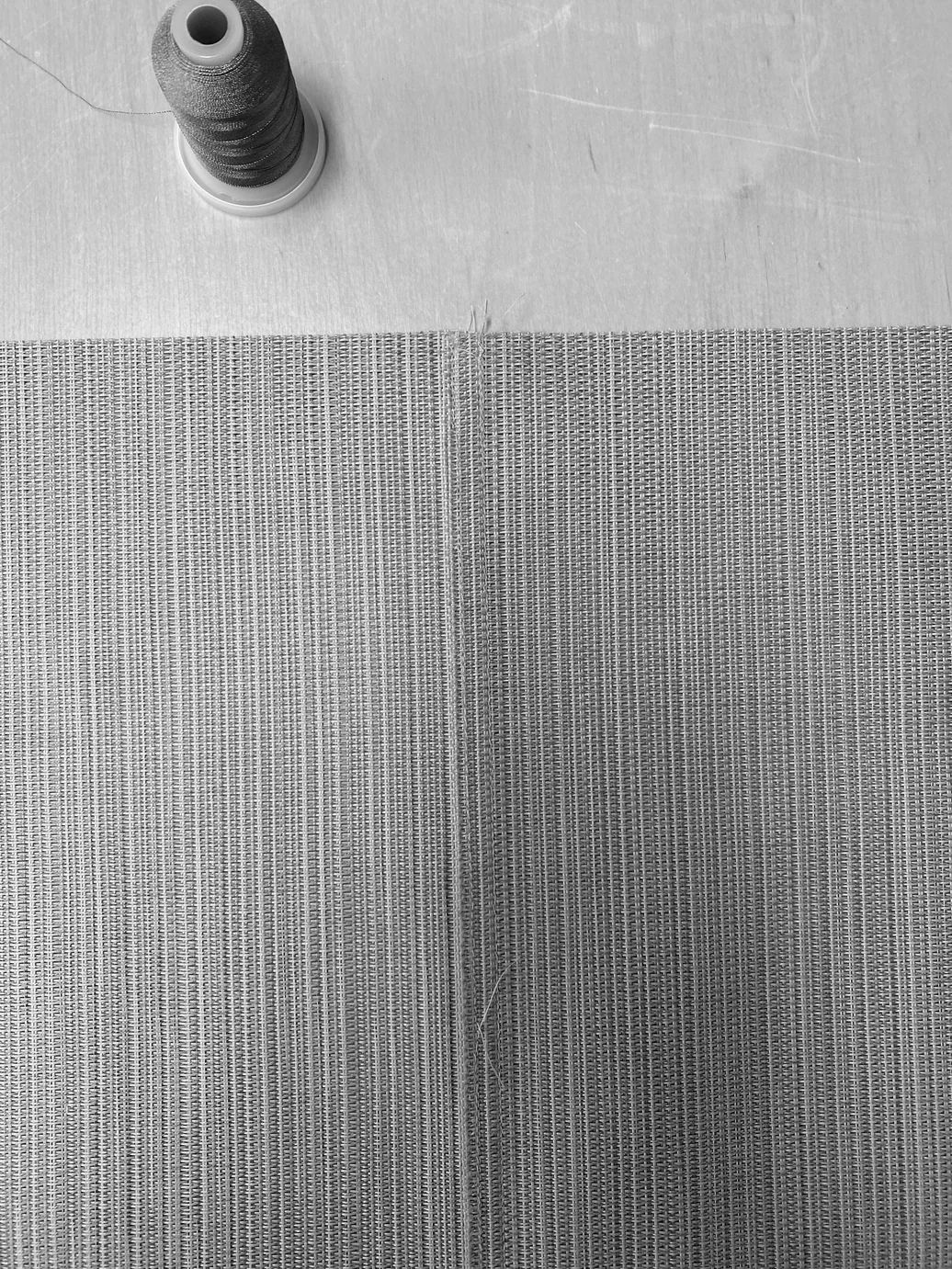 Close-up of the woven fabric texture with thread spool