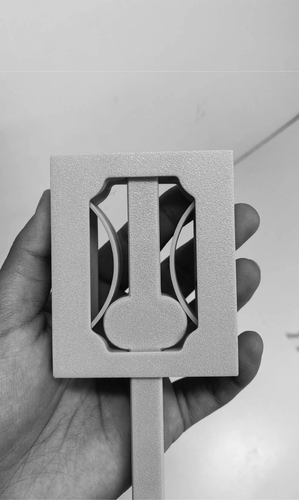 Second view of mechanism in hand — front-on, handle in raised position