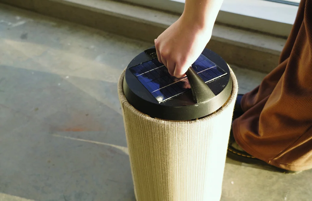 Hand gripping the raised handle, ready to carry the lamp