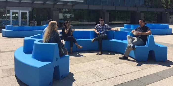 Group of people seated on blue modular outdoor seating