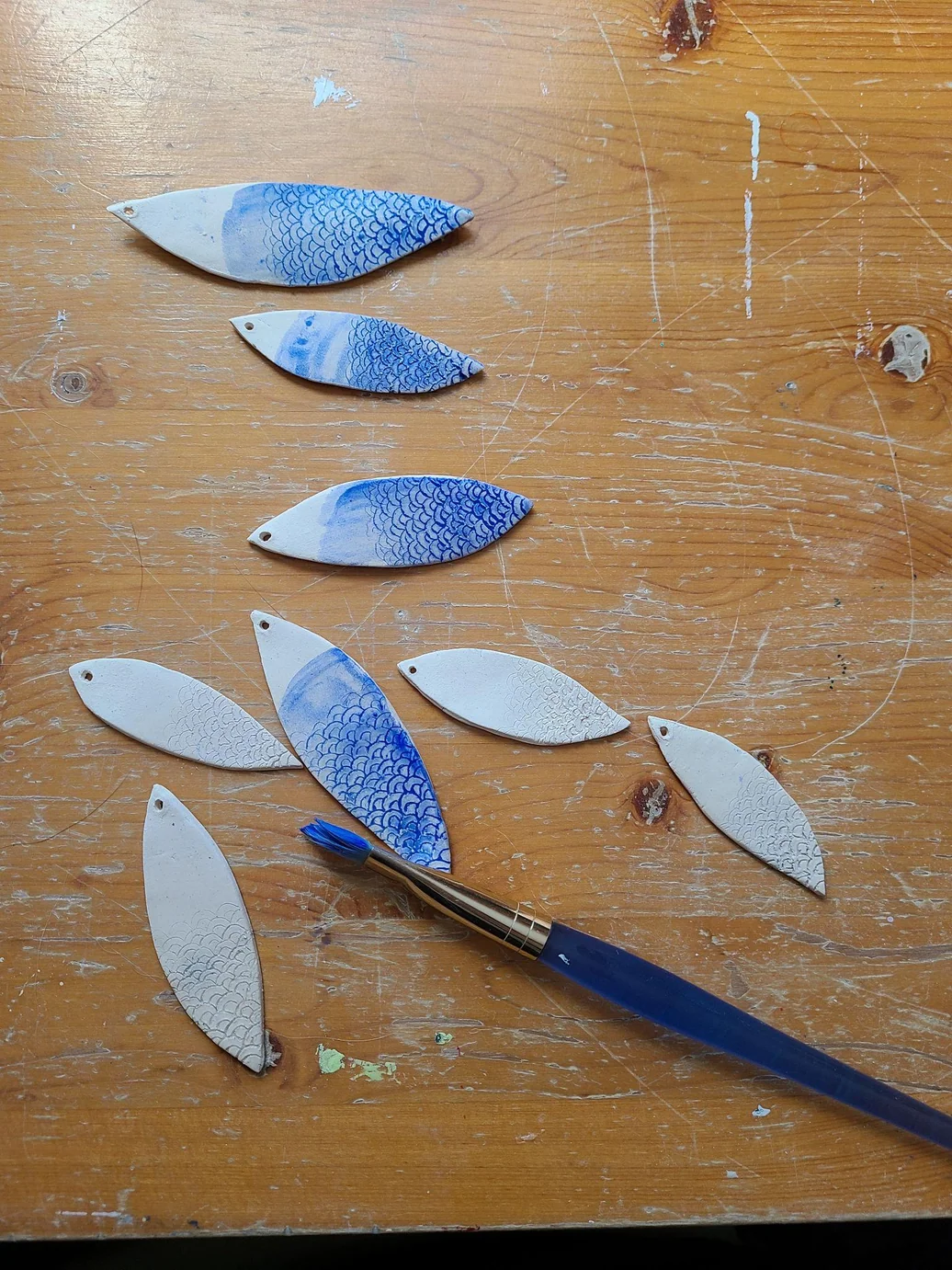 Hand-painting glaze onto the fired ceramic earring pieces